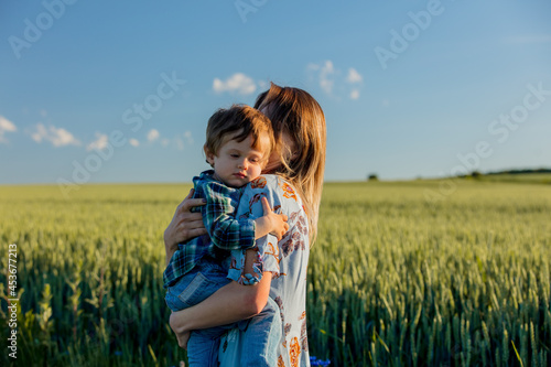 little boy hugs mom in a wheat field