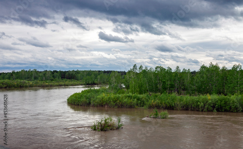 High water on the Kitoy River and a heavenly landscape in cloudy weather. photo