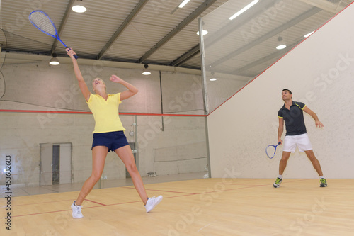 couple playing squash in indoor court