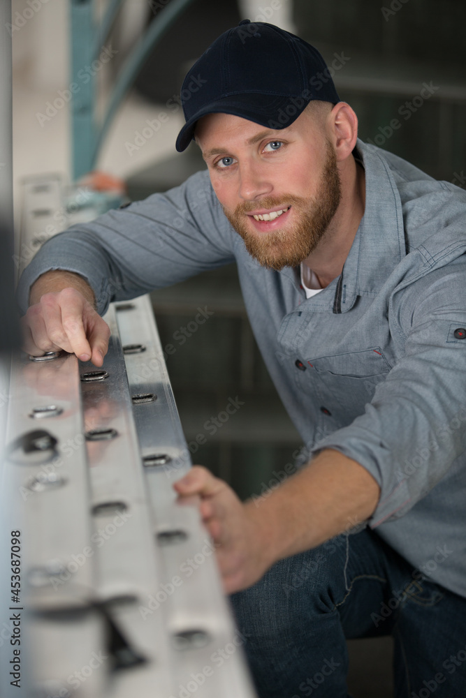 young male technician is next to ladder