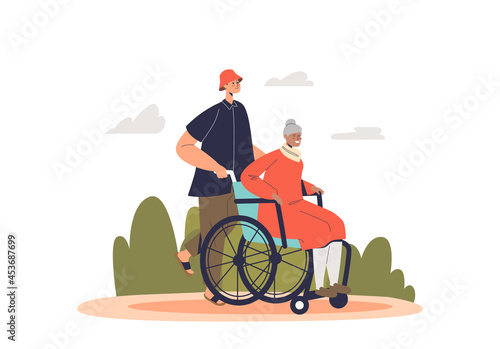 Young volunteer man helping senior lady on wheelchair. Guy carrying older grandmother woman