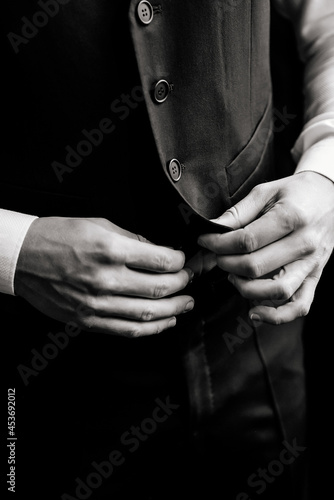 Close-up men's hands fasten the buttons. The groom in a suit, shirt. stylish classic menswear. © Fraupoc