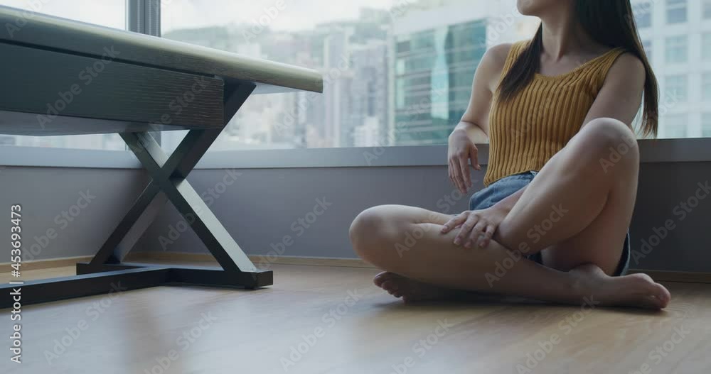 Woman sit floor and look outside the window Woman sit floor and look outside the window