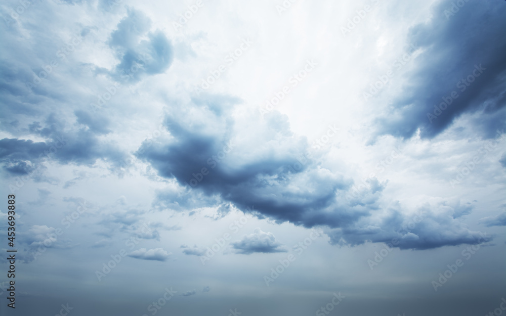 Obraz premium Beautiful gray fluffy clouds gathering and moving on dense cloudy sky. The sky is changing from pale grey to dark and stormy.