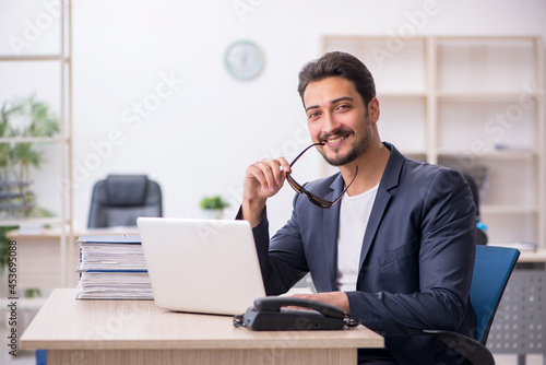 Young handsome employee working in the office