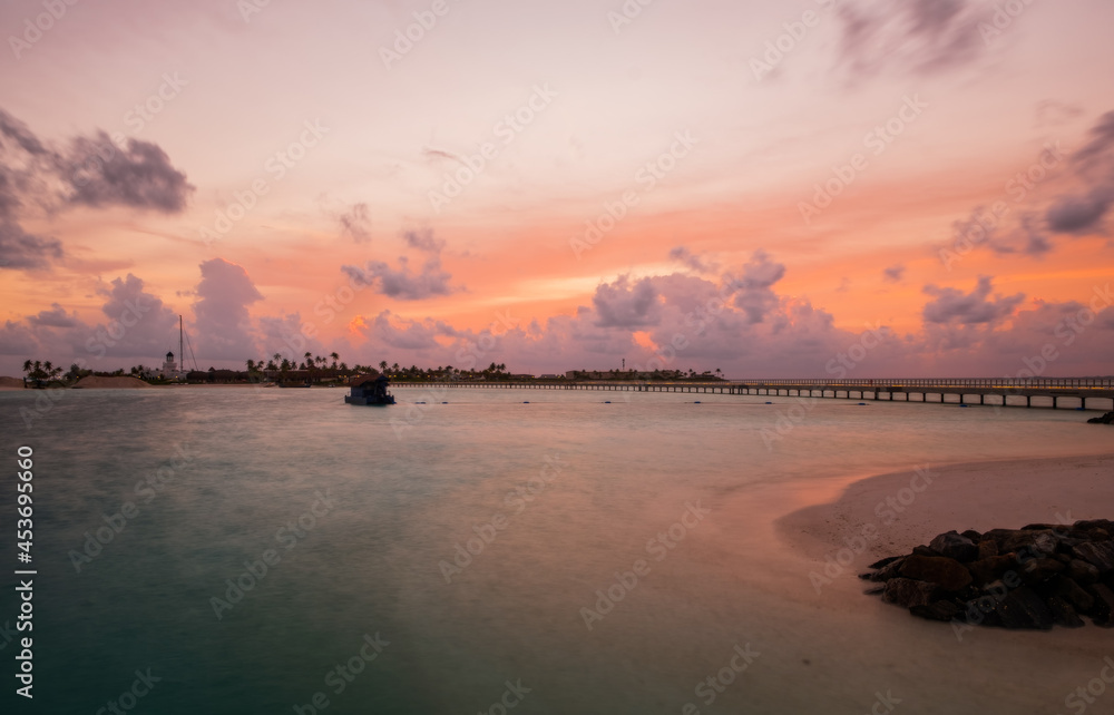 Palm trees on tropical coast at sunset. Maldives, june 2021. Long exposure picture