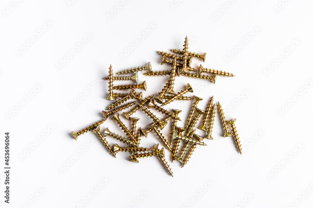 Metal screws on a white background. Set of building tools for repair. Metal screws on a white background. Set of building tools for repair.