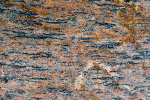 Wet orange and black striped patterned river rock as a nature background 