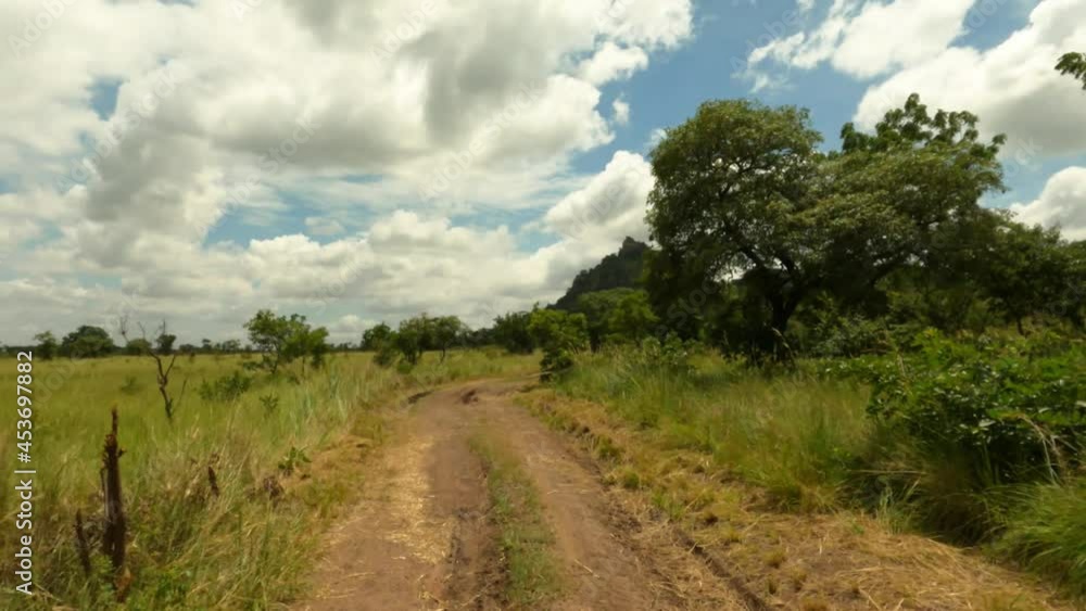 Drive rough dirt trail road savanna grass forest Ghana Africa POV 4K. Shai Hills Resource Reserve park is in Accra region of Ghana. Savanna, hills, mountains and valley forest and jungle environment. Drive rough dirt trail road savanna grass forest Ghana Africa POV 4K. Shai Hills Resource Reserve park is in Accra region of Ghana. Savanna, hills, mountains and valley forest and jungle environment.