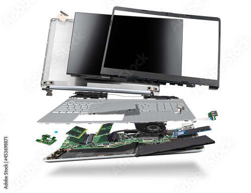 flying parts of a notebook computer. hardware components mainboard cpu processor display RAM cables and cooling fan flying out of silver laptop PC case isolated white exploded view background photo