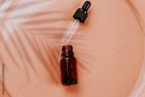 Abstract cosmetic laboratory. Bottles of dark amber glass on a beige liquid background. Natural cosmetics for care, homeopathy. Flat style, top view
