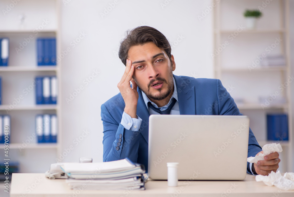 Young male employee suffering at workplace Young male employee suffering at workplace
