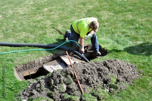 A workman pumping out a backyard septic tank. photo