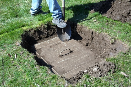 Digging up a home lawn to uncover a septic tank to prepare for maintenance. photo