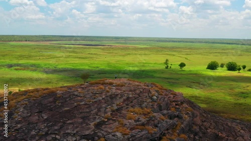 Hiker Standing On Top Of Ubirr Rock At Kakadu National Park In Northern Territory Of Austalia. - Aerial Drone Shot photo