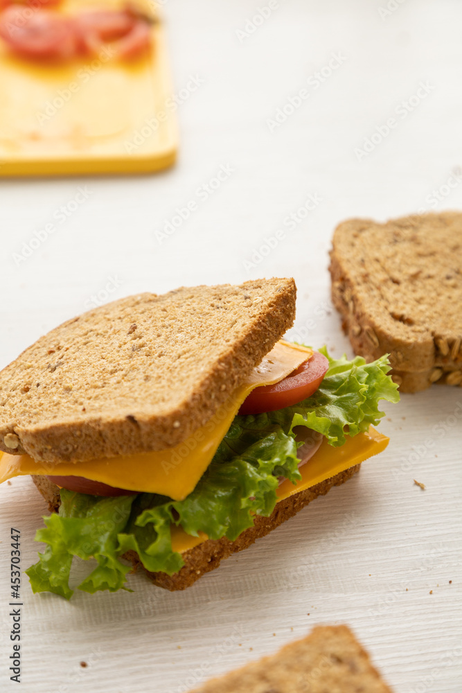 delicious homemade sandwiches, prepared with fresh ingredients, armed with whole wheat bread, cheese, lettuce on a table together, snack