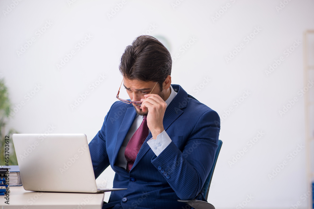 Young male employee working at workplace Young male employee working at workplace