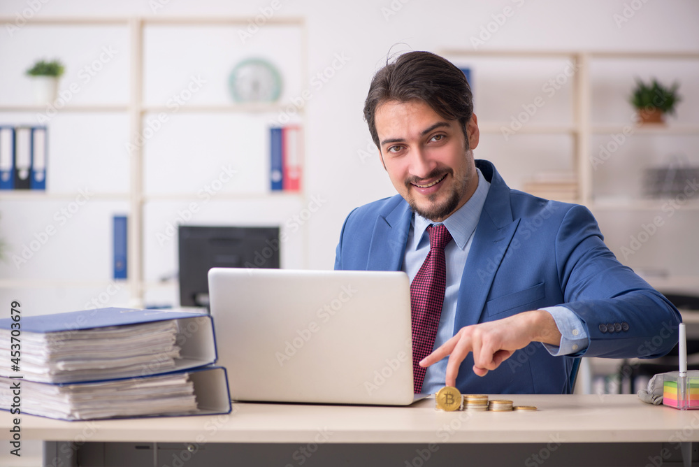 Young man earning money via Internet in cryptocurrency concept Young man earning money via Internet in cryptocurrency concept