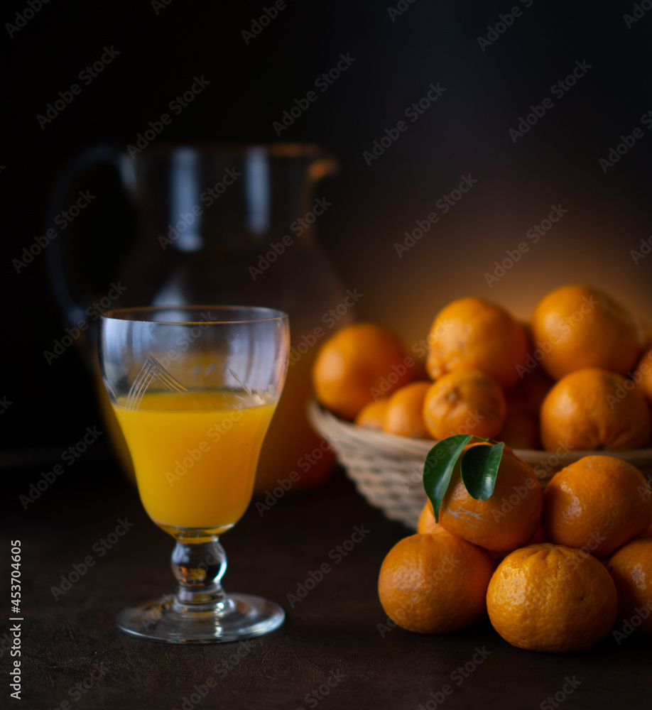 glass with orange juice (oranges and tangerines in the background) glass with orange juice (oranges and tangerines in the background)