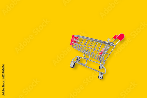 Empty shopping trolley on yellow background. concept of Sale and buy in mall market shop. Copy space