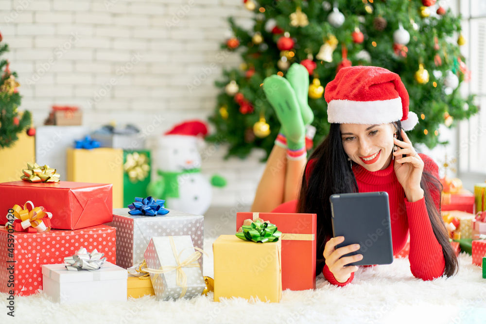 Pretty woman with Christmas costume hold tablet and smile with happiness during Christmas festival. Pretty woman with Christmas costume hold tablet and smile with happiness during Christmas festival.