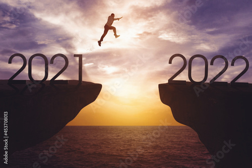 Young businessman jumps gap from 2021 to 2022