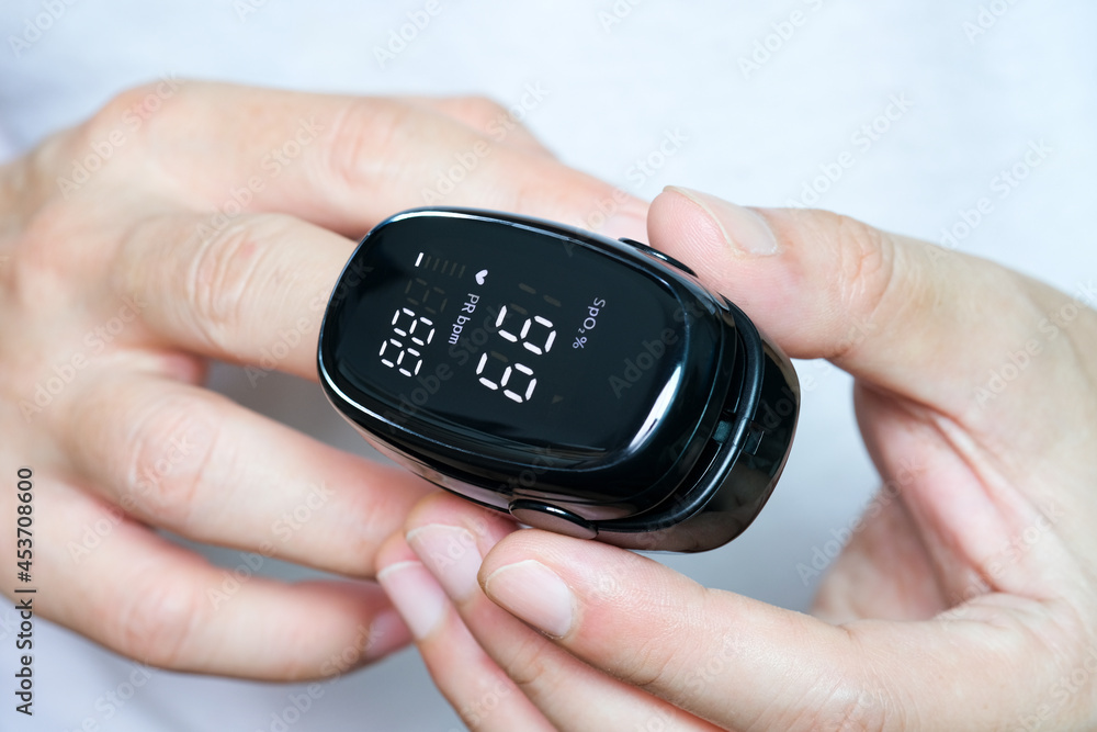 Fototapeta premium A device to measure the oxygen saturation of a person at the fingertips. And checking oxygen depletion is an emergency sign of pneumonia caused by the COVID-19 virus.