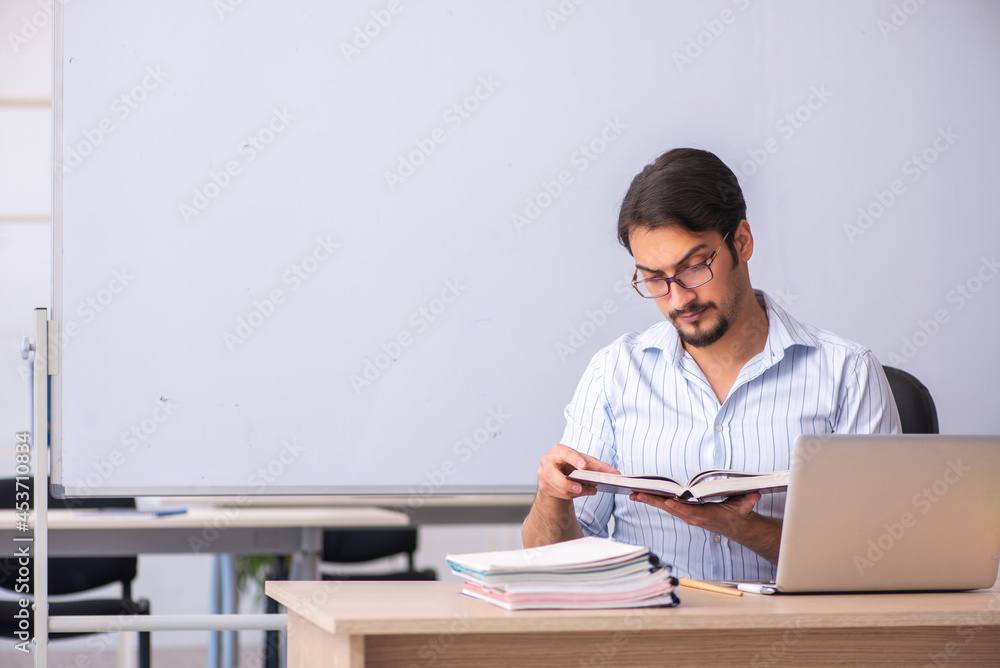 Young male teacher in front of whiteboard Young male teacher in front of whiteboard