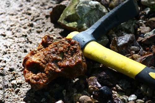 Piece of flint and pickaxe, searching for stones in nature