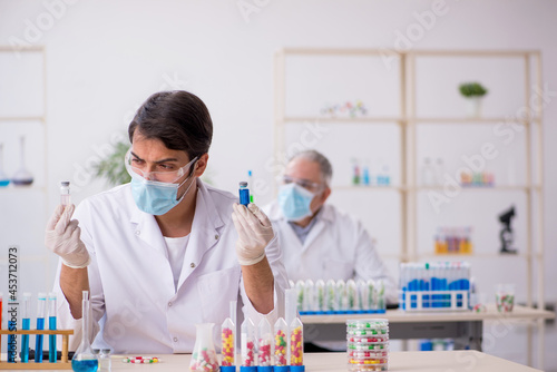 Two male chemists in drugs synthesis concept at the lab