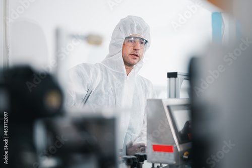 Scientists wearing protective clothing Inspect mask making machines in a laboratory at an industrial plant. Anti-virus production warehouse. concept of safety and prevention coronavirus covid-19.