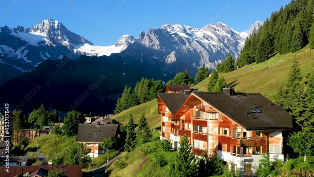 Cinematic drone shot of Murren, a traditional Walser mountain village in the Bernese Highlands of Switzerland. Flying over homes and hotels with mountains in the distance Cinematic drone shot of Murren, a traditional Walser mountain village in the Bernese Highlands of Switzerland. Flying over homes and hotels with mountains in the distance