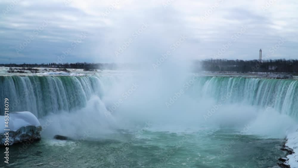 Panning long shot of Niagara falls high mist winter cloudy day Slow Motion Panning long shot of Niagara falls high mist winter cloudy day Slow Motion