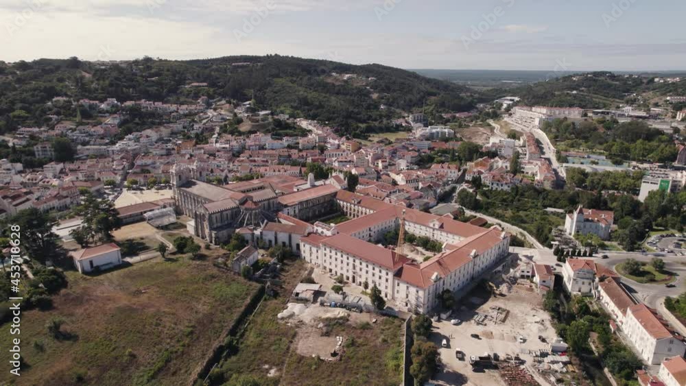 Portugal historical cityscape and catholic monastic complex Alcobaça monastery, aerial pan shot.