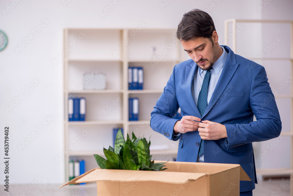 Young male employee in business relocation concept Young male employee in business relocation concept