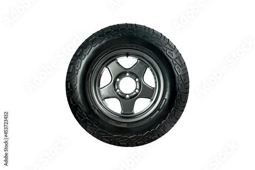 All terrain tire designed for use in all road conditions with alloy wheel isolated on white background.