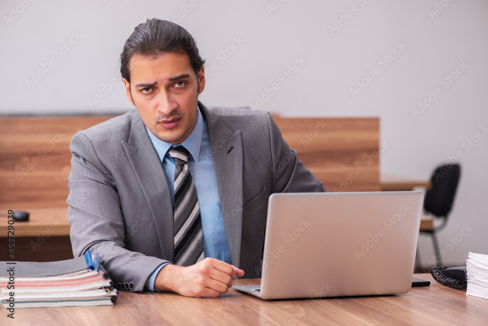 Young male employee working in the office Young male employee working in the office