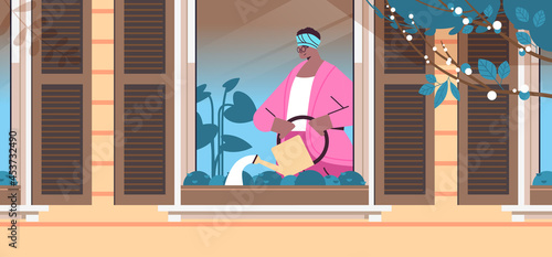 senior woman holding watering can and pouring plants home gardening old age concept