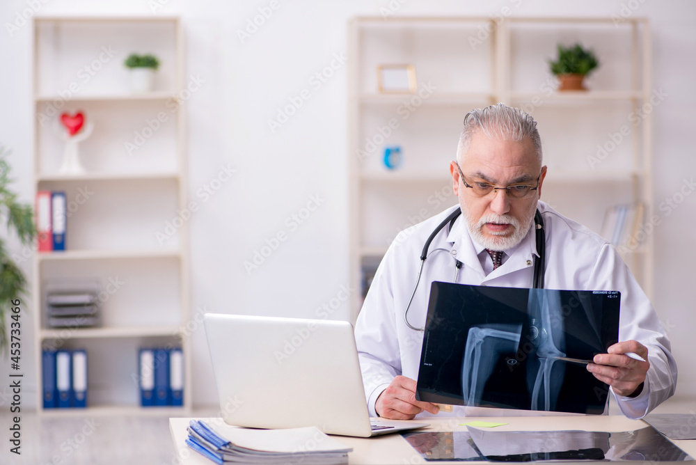 Old male doctor radiologist working in the clinic Old male doctor radiologist working in the clinic