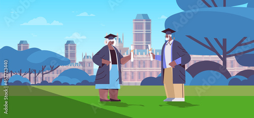 senior man woman graduated students standing together in park graduates celebrating academic diploma degree