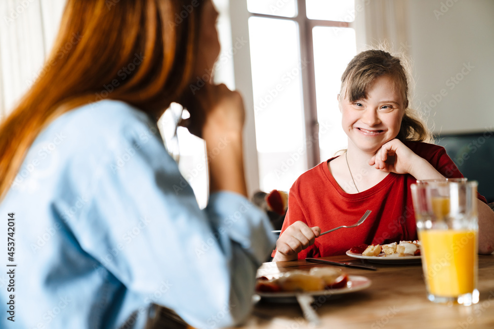 White woman and her daughter with down syndrome having breakfast White woman and her daughter with down syndrome having breakfast