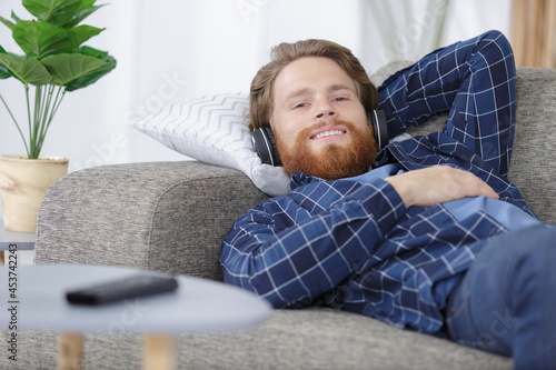 man at home on sofa listening to music