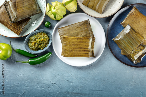 Fotografie, Obraz Tamale, traditional dish of the cuisine of Mexico, various stuffings wrapped in green leaves, top shot with copy space