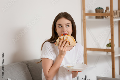 Beautiful young woman eatin...