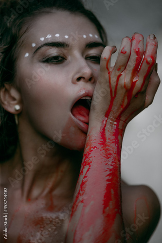 Glamorous photos of wild woman showing blood and gore dripping from the mouth photo