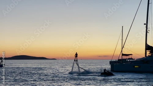 Silhouette Of A Rider Standing On A Hydroflying Device In The Sea In The Island Of Hvar In Croatia At Sunset. wide shot photo