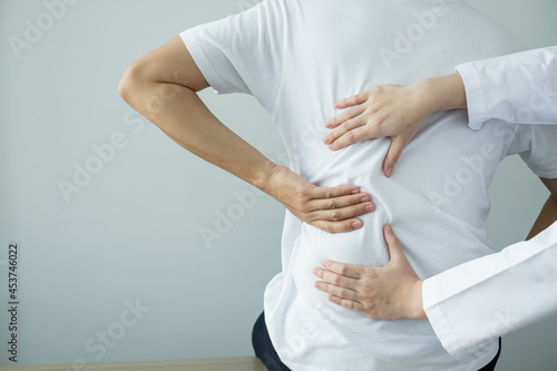 Female physiotherapists provide physical assistance to male patients with back injuries back massages for relaxation and muscle recovery in the rehabilitation center