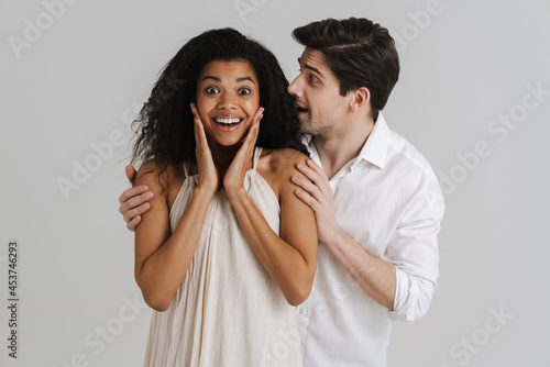 European unshaven man hugging her smiling black girlfriend