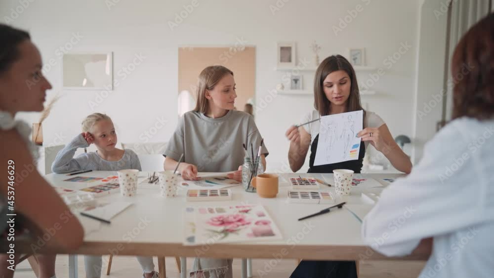 Happy mother and daughter enjoying at drawing class. Creative family spending time in art studio. Female artist drawing in workshop
