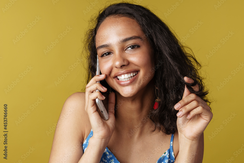 Fototapeta premium Young hispanic woman smiling while talking on mobile phone